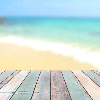 Bulanık doğa manzaralı ahşap masa üstü tropik plaj ve mavi gökyüzü, tatil arka planı konsepti ürününüzü görüntülemek veya montajlamak için kullanılabilir.