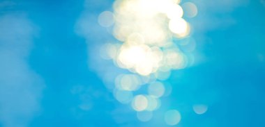 Yumuşak odak ışığı efektleri dalgalı, mavi su arka planında.