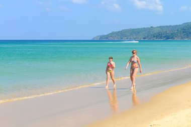 PHUKET, THAILAND - 25 Mart 2015: Boş zamanlarında, güzel plajda birkaç insan 25 Mart 2015 'te Phuket, Taylan' da Karon plajında vakit geçirir.