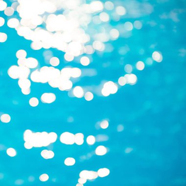 Yumuşak odak ışığı efektleri dalgalı, mavi su arka planında.