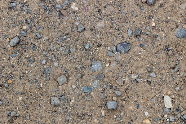 Kumlu doku, sahil, nehir yakası. Küçük taşlar, parlak güneş ışığı ile büyük kum. Dinlenme, yaz, plaj.