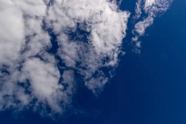 Wolken tegen blauwe hemel als achtergrond — Stockfoto