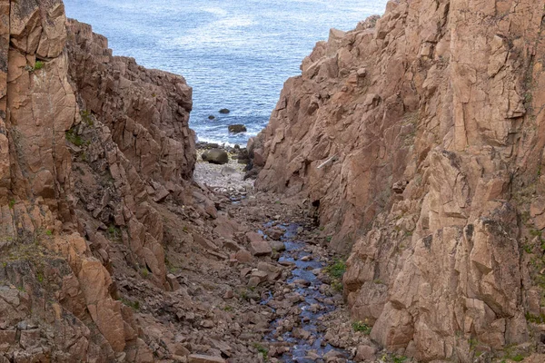 Río se encuentra con el océano a lo largo de una costa rocosa con flujo de agua pesada en una zona forestal, río Motion —  Fotos de Stock