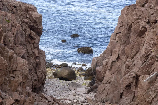 Floden möter havet längs en stenig strandlinje med tungt vattenflöde i ett skogsområde, motion River — Stockfoto