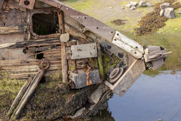 Altes Schiffswrack oder verlassenes Wrack, kaputtes Fischerboot liegt auf der Seite in Ufernähe — Stockfoto