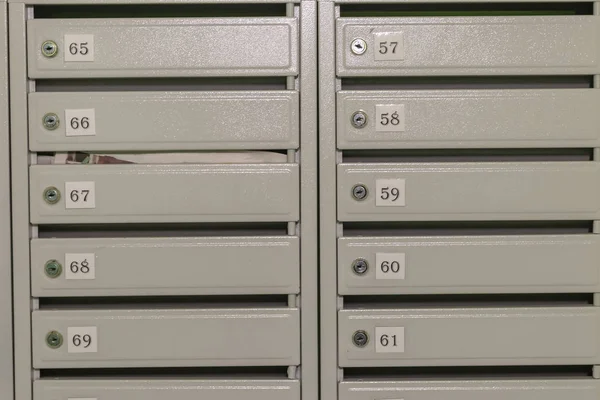 Metall brevlådor med lägenhetsnummer målade i grått. — Stockfoto