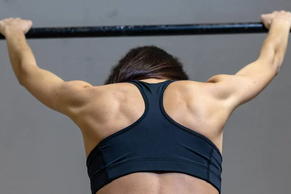 Flickan är engagerad i baren i gymmet — Stockfoto