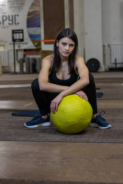 Het meisje is bezig met een CrossFit bal in de sportschool — Stockfoto