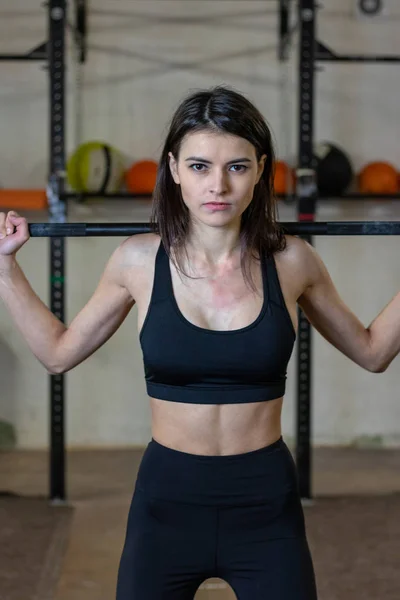 Flickan är engagerad med en skivstång i gymmet — Stockfoto