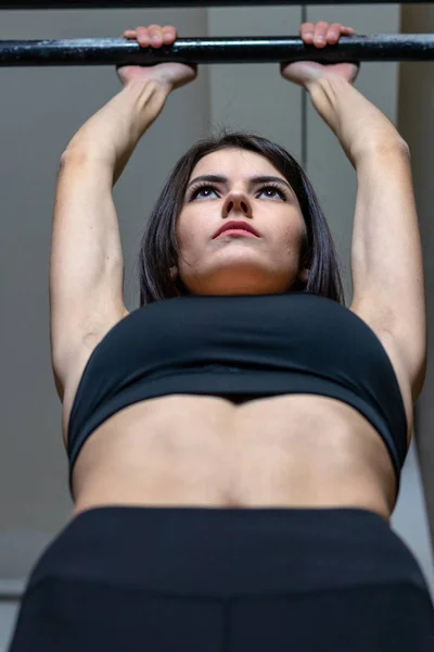 Flickan är engagerad i baren i gymmet — Stockfoto