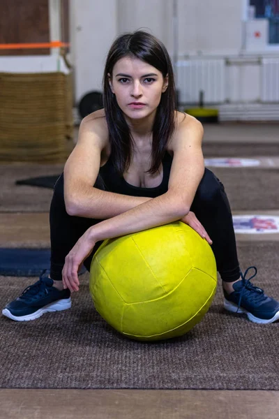 Het meisje is bezig met een CrossFit bal in de sportschool — Stockfoto