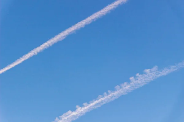 Біла стежка з літака проти блакитного неба — стокове фото