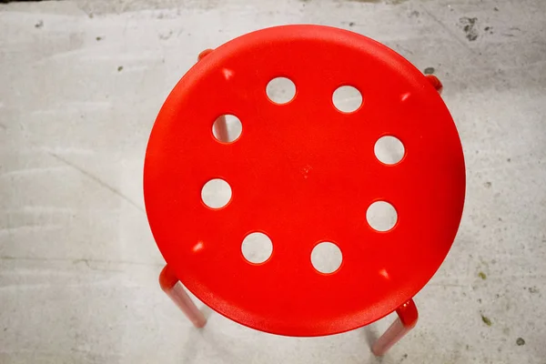 Red stool on the cement floor, texture, background — Stock Photo, Image