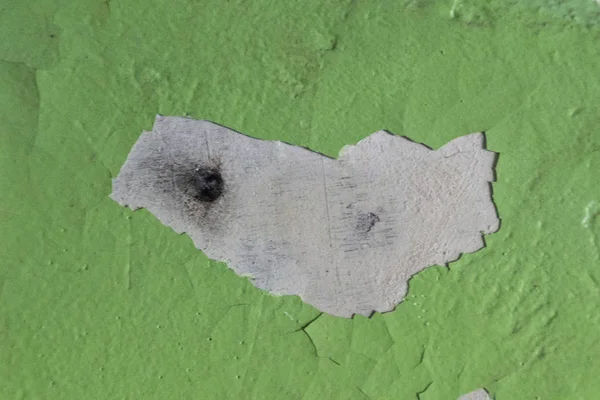 A bullet hole in a painted wall