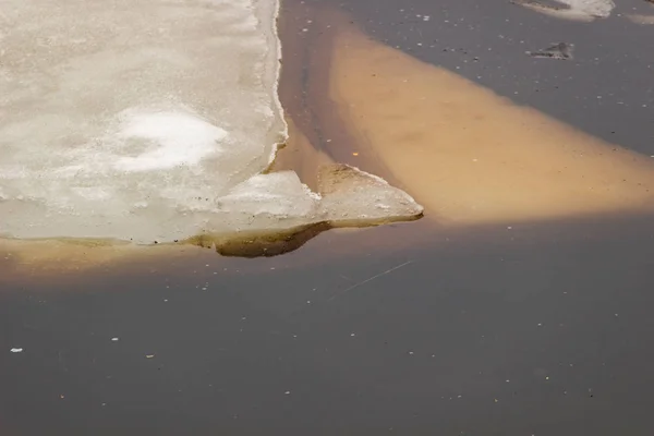 O gelo no lago na água lamacenta — Fotografia de Stock