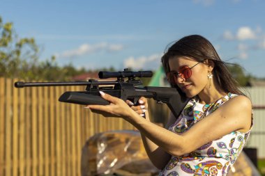 Dış ormanda av tüfeği ile nişan güzel avcı kız. Optik görme karabina