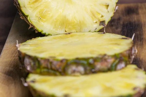 Ripe pineapple and pineapple slices on a wooden background tropical fruits