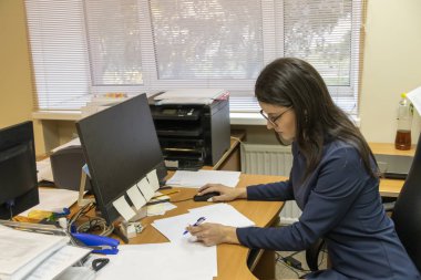 Genç kız düşünceli ofiste monitöre bakar