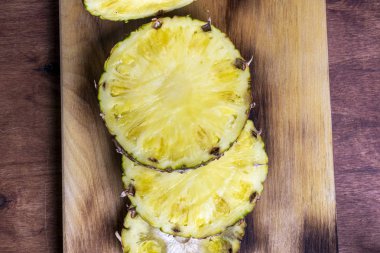 Olgun ananas ve ahşap arka plan tropikal meyve ananas dilimleri.