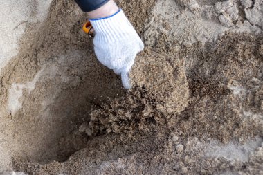 İnşaat ve kazı çalışmaları sırasında imar yer şantiye gerçekleştirir bulanık modern Ekskavatör mavi boilersuit ve iş eldivenleri kürek ile işçi açıktır