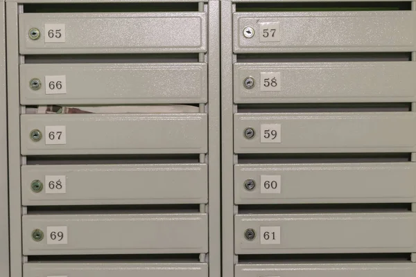 Metal mailboxes with apartment numbers painted in gray. — Stock Photo, Image