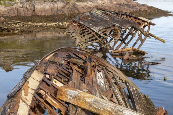 旧的沉船或废弃的沉船, 破碎的渔船躺在它的一侧附近的岸边 — 图库照片