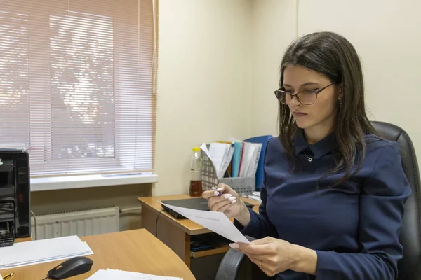 Genç kız düşünceli ofiste monitöre bakar