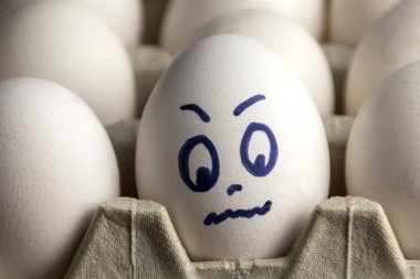 Karton kutuda güzel yumurtalar. Duyguları olan yumurtalar. Farklı yüzler üzerine boyanmış karton kutuda beyaz yumurtalar. Erkek ve kız.