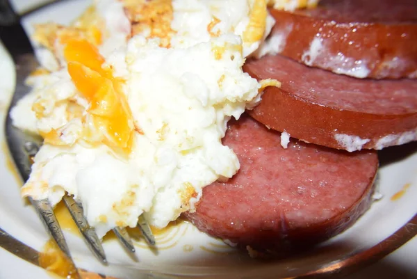 Смажені яйця з ковбасою та овочами у тарілці смачна їжа — стокове фото