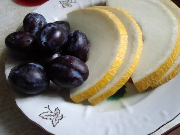 Söt melon är på en tallrik skuren i skivor — Stockfoto