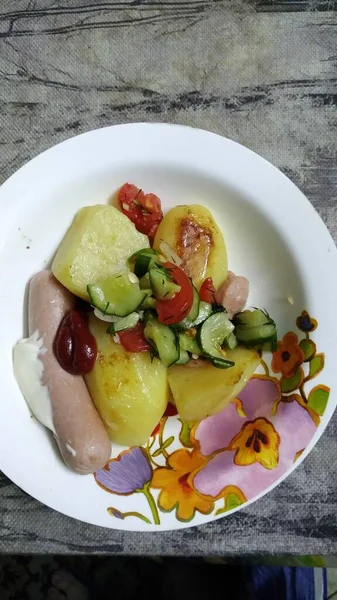 Kartoffeln mit Gemüse und Würstchen in einem Teller leckere Snacks — Stockfoto