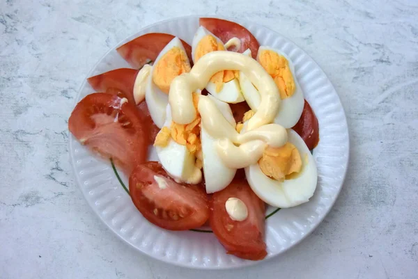 Une assiette d "œufs de tomates avec mayonnaise sur la table — Photo