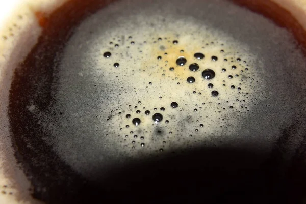 Macrofotografía, espuma de café en un vaso sobre la mesa — Foto de Stock