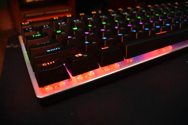 Teclado mecânico com luz de fundo sobre a mesa, periféricos — Fotografia de Stock