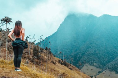 mujer caminanda observando cordillera valle del cocora Salento Quindio