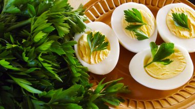 Lezzetli haşlanmış yumurta ve siyah arka plan üzerine maydanoz.