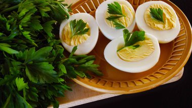 Lezzetli haşlanmış yumurta ve siyah arka plan üzerine maydanoz.