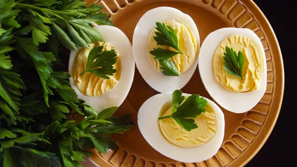 Lezzetli haşlanmış yumurta ve siyah arka plan üzerine maydanoz.