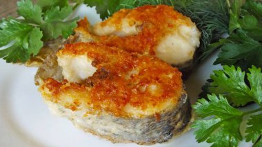 Beyaz tabakta yeşillikleri ile lezzetli kızarmış pike.