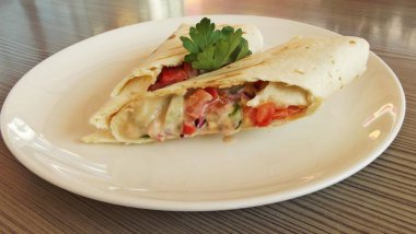 Pita ekmeği beyaz tabakta taze sebze.