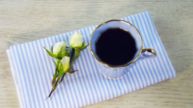 Mavi peçeteye hoş kokulu kahve ve beyaz güller.