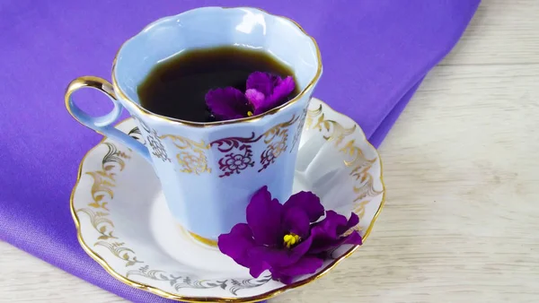 Een Kopje Koffie Een Paarse Bloem Een Paarse Achtergrond — Stockfoto