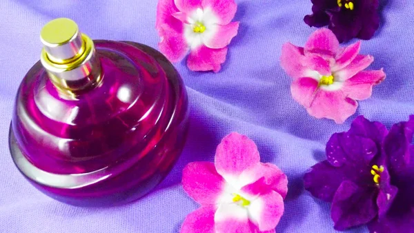 Perfume Una Botella Púrpura Flores Violetas Sobre Fondo Lila — Foto de Stock