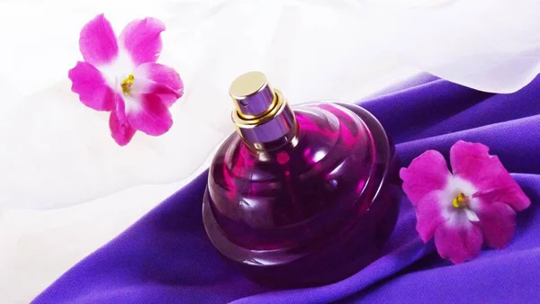 Parfüm Einer Lila Flasche Und Violette Blumen Auf Fliederfarbenem Hintergrund — Stockfoto