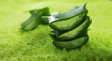 Yararlı sulu. Aloe yeşil havlu arka planda parçaları.