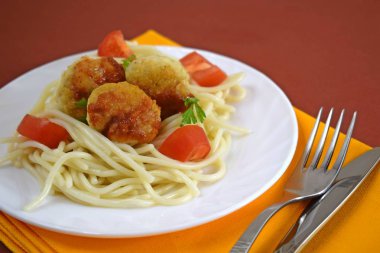 Köfte domates ve beyaz bir plaka üzerinde otlar ile lezzetli makarna.