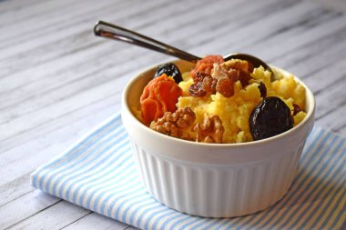 Mısır ezmesi ve kurutulmuş meyve ahşap arka plan üzerinde yararlı yulaf lapası.