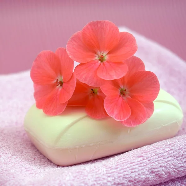 Fragrant flower soap on a pink towel.