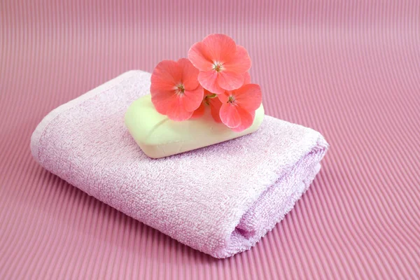 Fragrant flower soap on a pink towel.