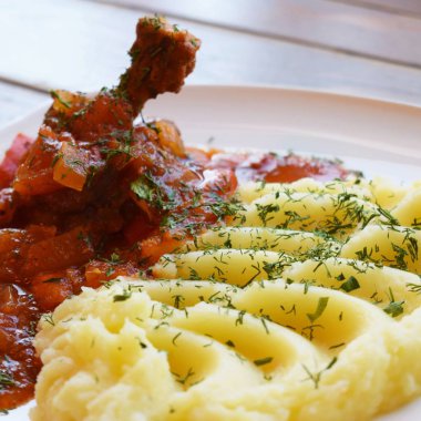 Tavuk sosu ve sebze ve otlar beyaz tabakta ile patates püresi ile.